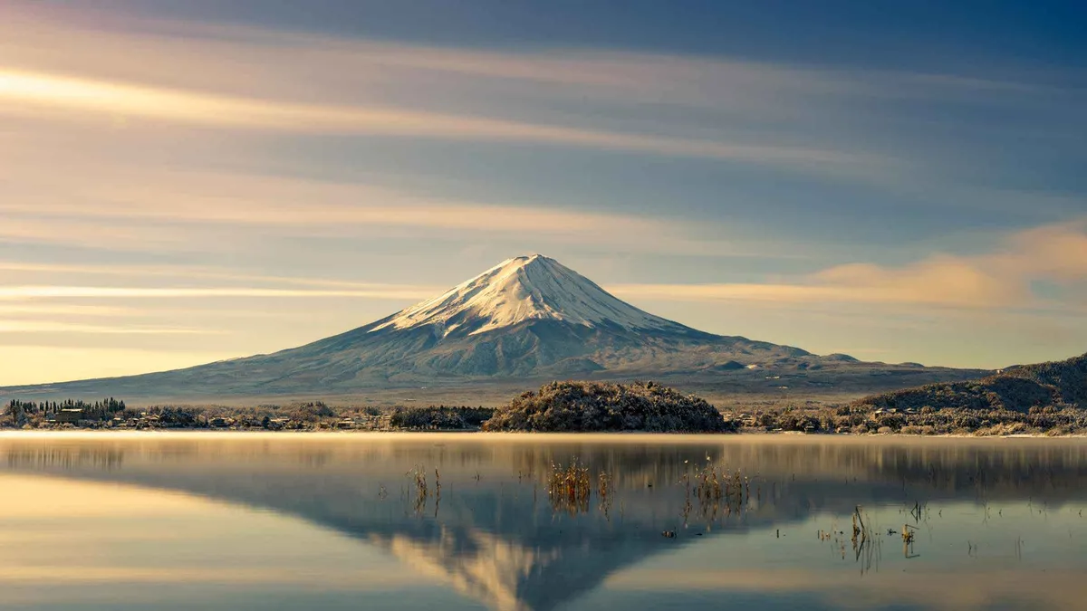 A sightseeing boat on Lake Kawaguchi with Mount Fuji behind on a shared coach day from Tokyo